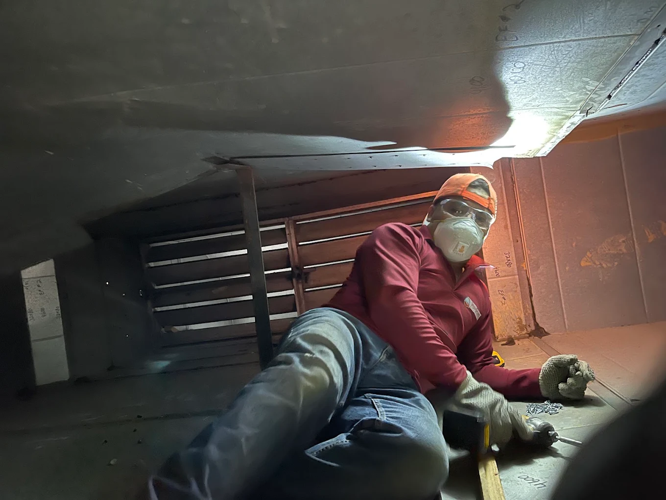 Crawlspace duct repair and sealing — the work most contractors skip. ProActive technician in respirator repairing ductwork inside a tight crawlspace in Annapolis, MD
